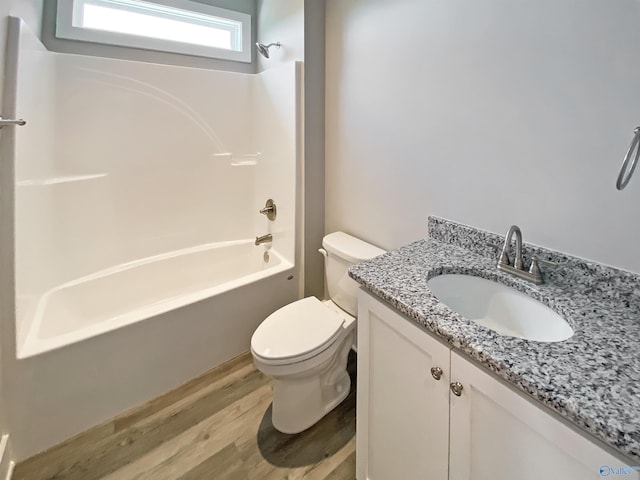 full bathroom featuring vanity, toilet, hardwood / wood-style flooring, and shower / washtub combination