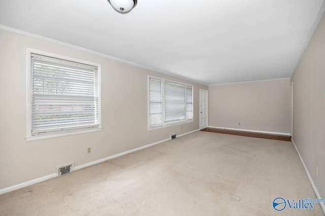 carpeted empty room featuring baseboards, visible vents, and ornamental molding