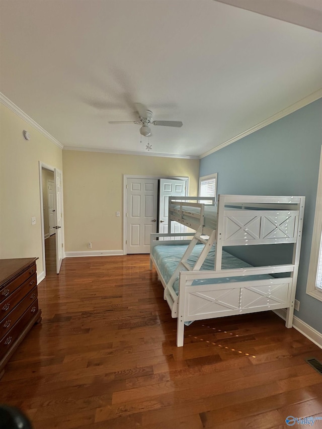 bedroom with ornamental molding, dark wood-type flooring, and ceiling fan