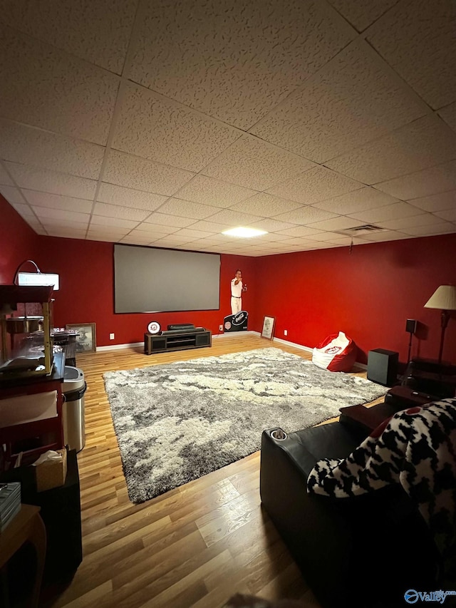 home theater featuring hardwood / wood-style flooring and a paneled ceiling