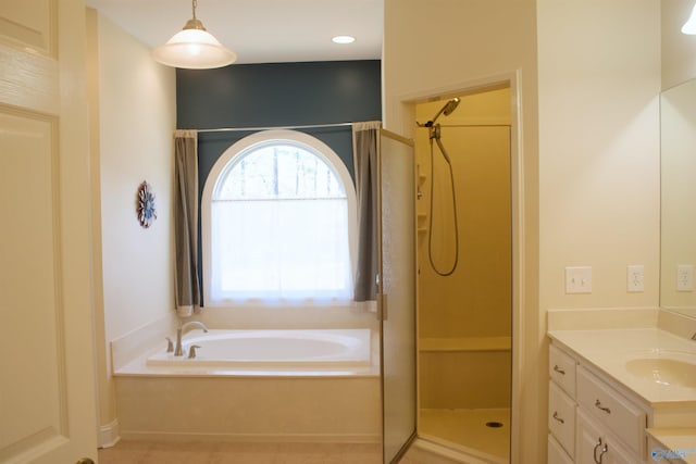 bathroom with vanity and shower with separate bathtub