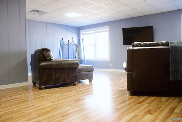 living room featuring a paneled ceiling and light hardwood / wood-style floors