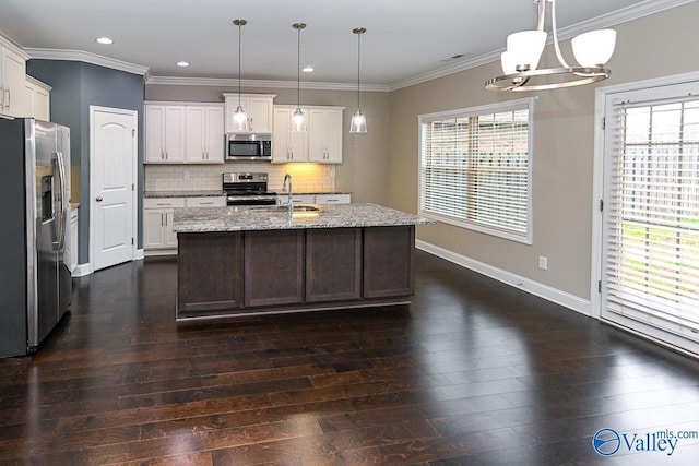 kitchen featuring dark hardwood / wood-style floors, a kitchen island with sink, stainless steel appliances, and hanging light fixtures