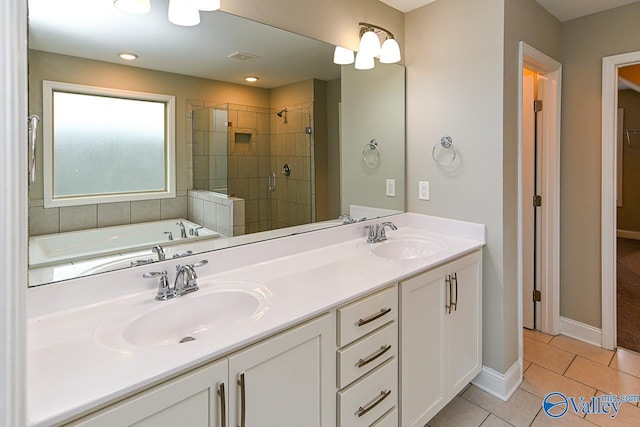 bathroom featuring plus walk in shower, vanity, and tile patterned floors