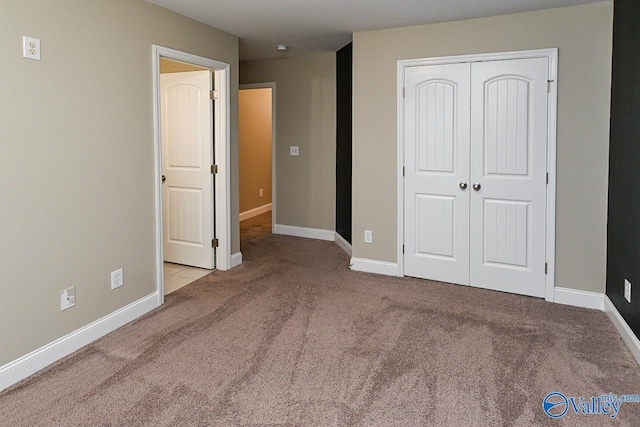 unfurnished bedroom with light carpet and a closet