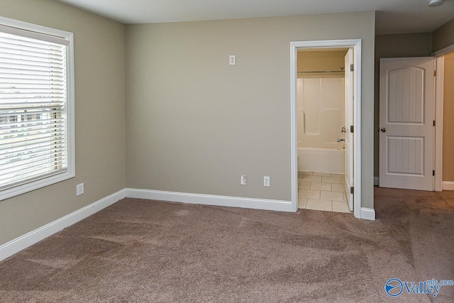 unfurnished bedroom featuring carpet flooring and ensuite bathroom