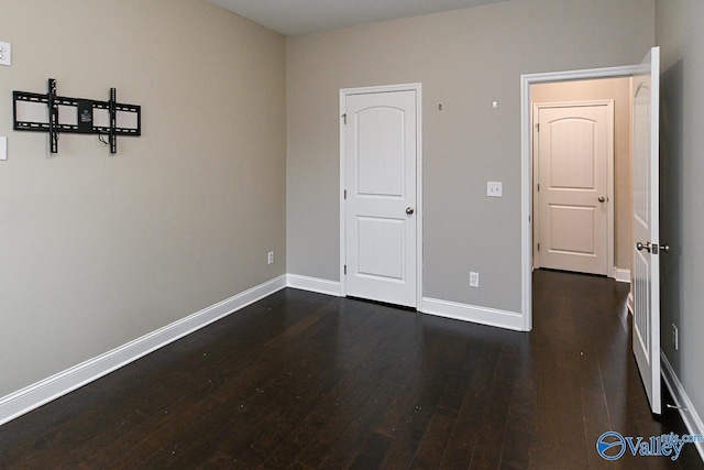 unfurnished bedroom with dark hardwood / wood-style floors