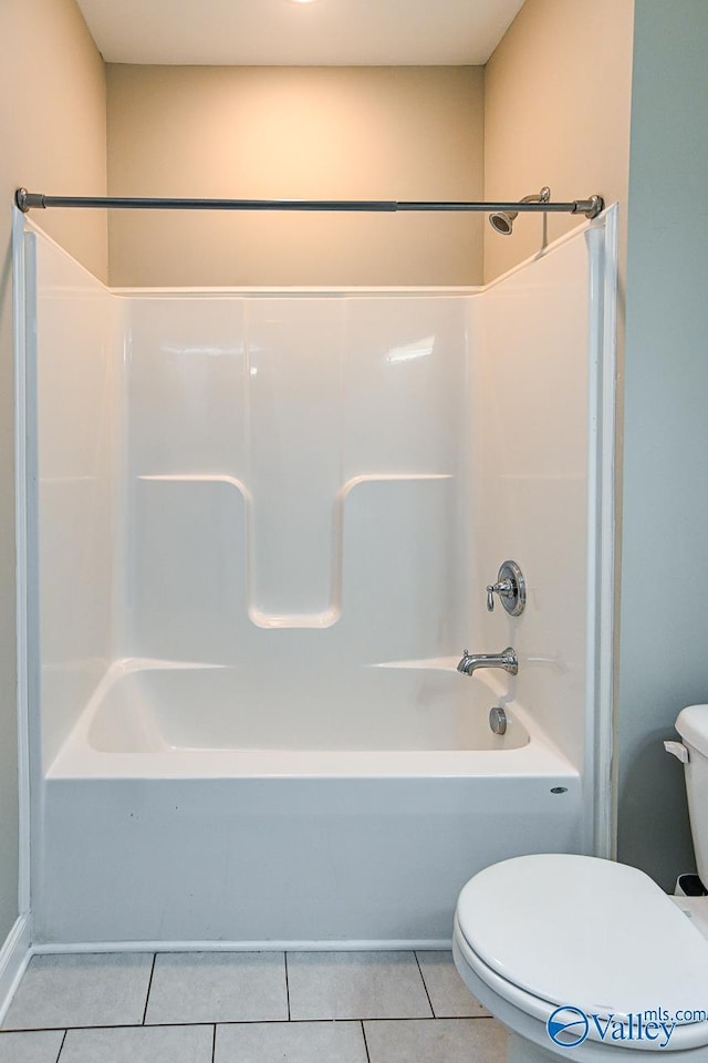 bathroom with tile patterned floors, toilet, and shower / washtub combination