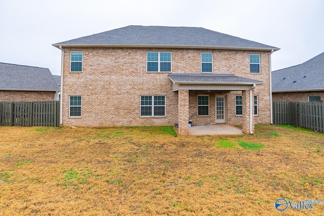 rear view of property with a yard and a patio