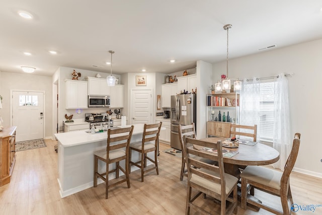 dining space with recessed lighting, light wood-style flooring, and visible vents