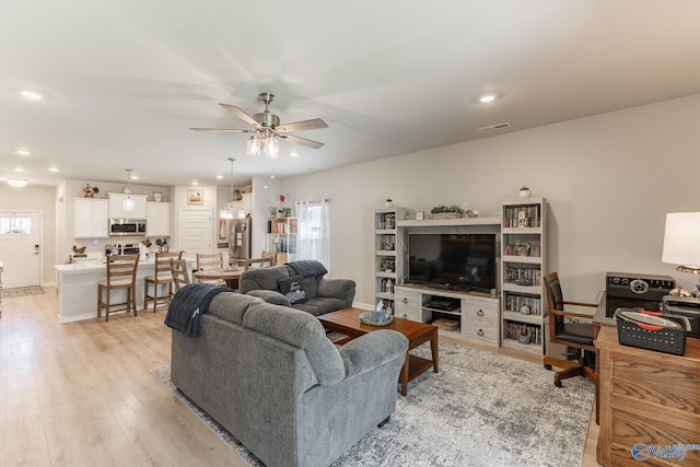 living room featuring light wood-style flooring, baseboards, visible vents, recessed lighting, and a ceiling fan