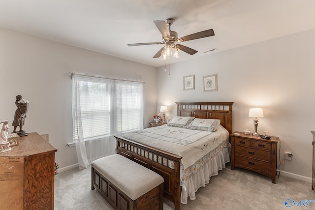 bedroom featuring light colored carpet, ceiling fan, baseboards, and visible vents
