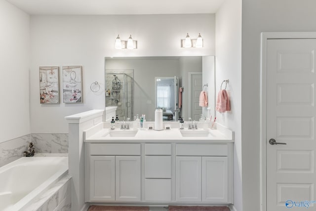 bathroom featuring a bath, a sink, a shower stall, and double vanity