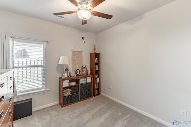 interior space featuring baseboards, light carpet, visible vents, and ceiling fan