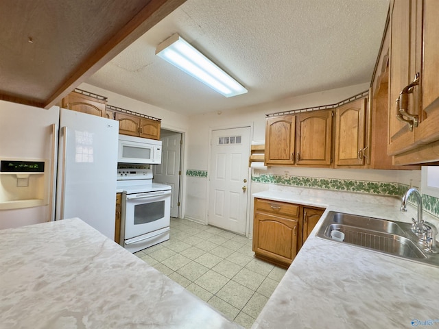 kitchen featuring a textured ceiling, white appliances, and sink