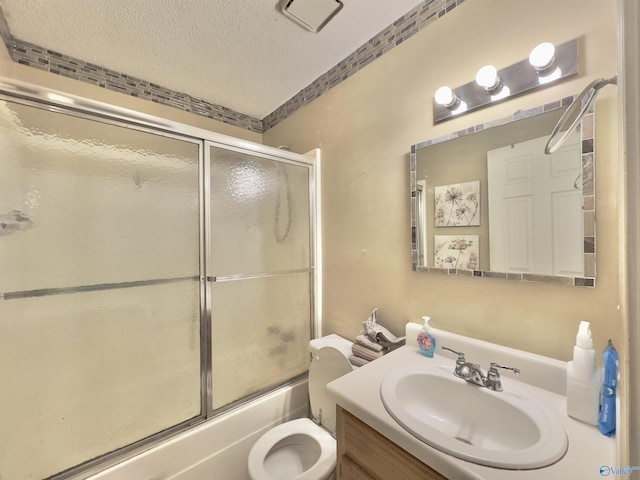 full bathroom featuring vanity, bath / shower combo with glass door, a textured ceiling, and toilet