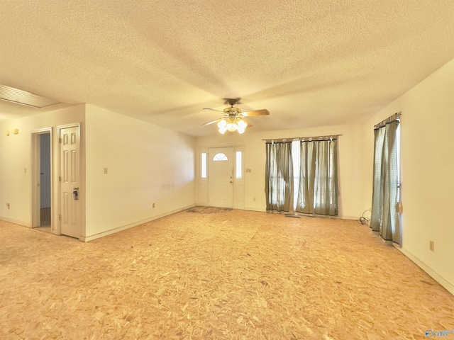 spare room with a wealth of natural light, a textured ceiling, and ceiling fan