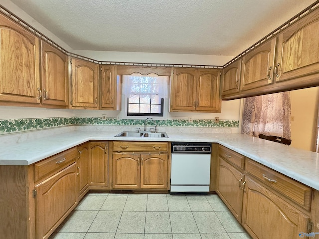 kitchen featuring dishwasher, light tile patterned floors, a textured ceiling, and sink