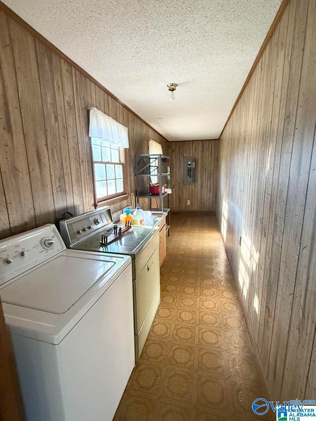 clothes washing area with crown molding, washer and dryer, a textured ceiling, and wood walls