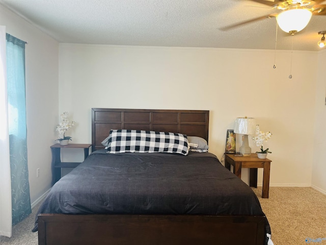 bedroom with ceiling fan, light carpet, and a textured ceiling