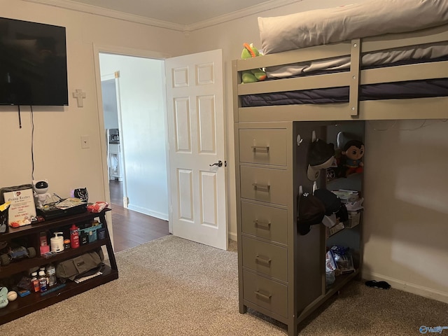 bedroom with ornamental molding and carpet