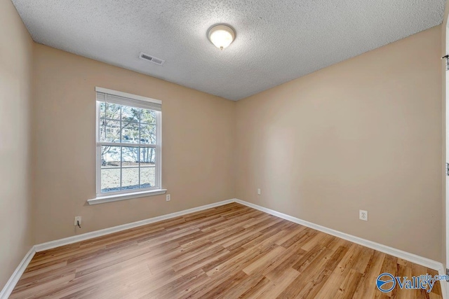 unfurnished room with a textured ceiling and light hardwood / wood-style flooring