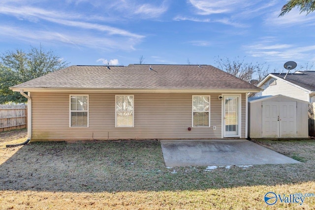 rear view of house featuring a yard, a storage unit, and a patio