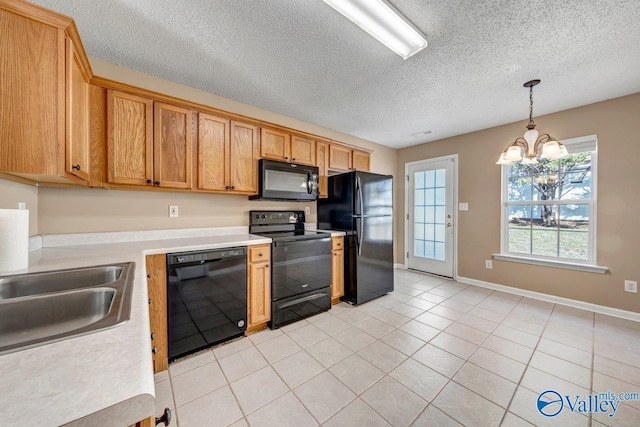 kitchen with decorative light fixtures, a textured ceiling, light tile patterned floors, black appliances, and a notable chandelier