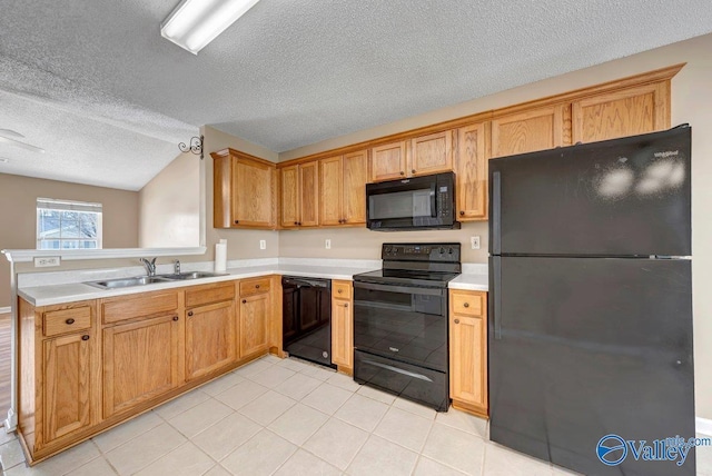 kitchen featuring a textured ceiling, black appliances, lofted ceiling, light tile patterned flooring, and sink