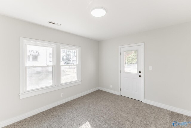 carpeted entryway with visible vents and baseboards