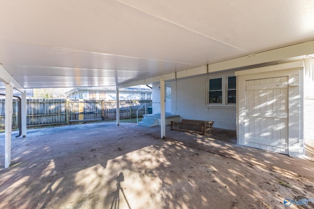 view of patio featuring a carport and fence