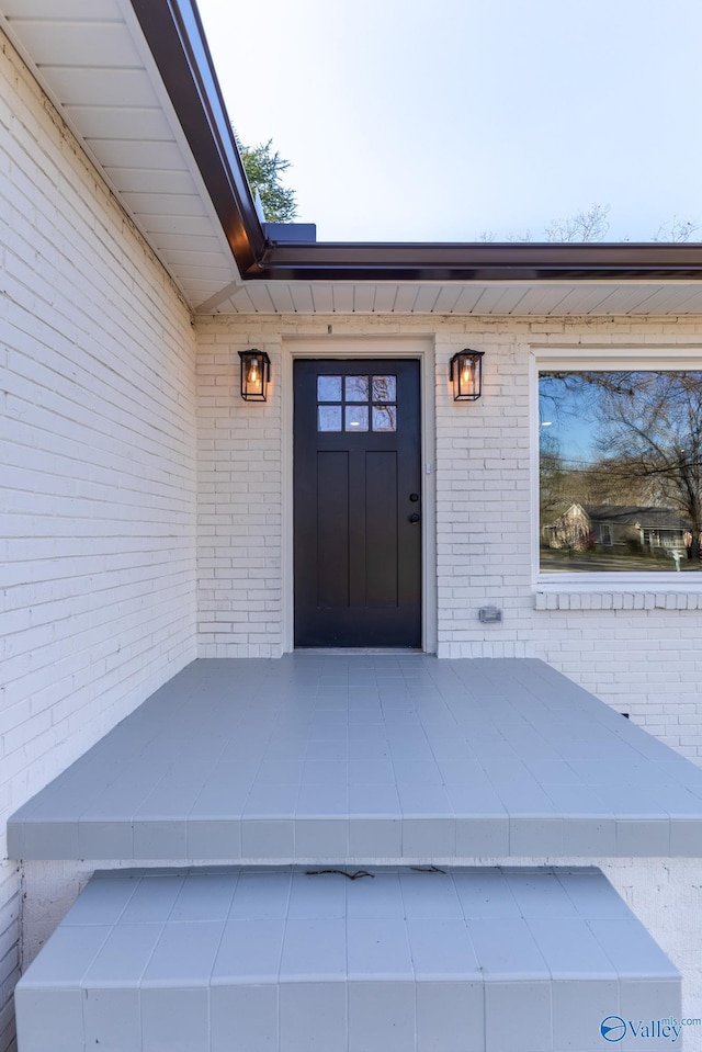 property entrance featuring brick siding