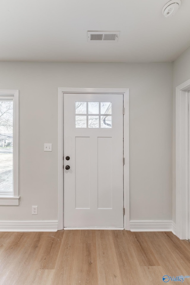 foyer entrance with visible vents, baseboards, and light wood-style floors