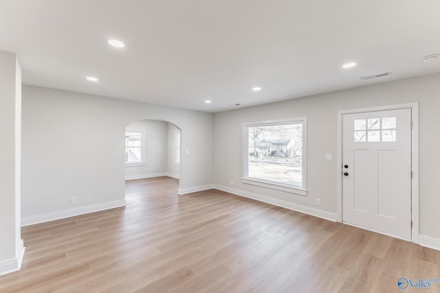 entryway featuring arched walkways, visible vents, recessed lighting, and light wood-type flooring