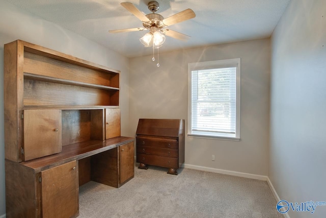 office space featuring light colored carpet, ceiling fan, and baseboards