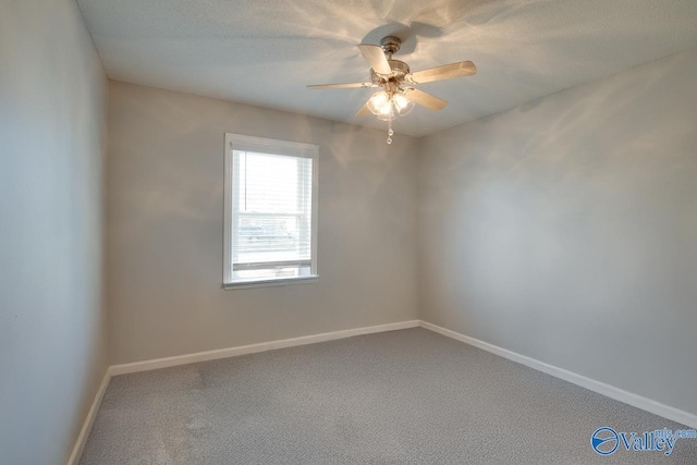 carpeted empty room with ceiling fan, a textured ceiling, and baseboards