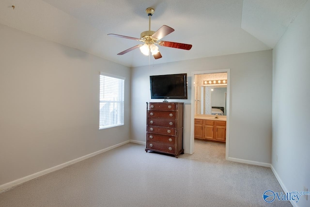 unfurnished bedroom featuring light carpet, ceiling fan, connected bathroom, and baseboards