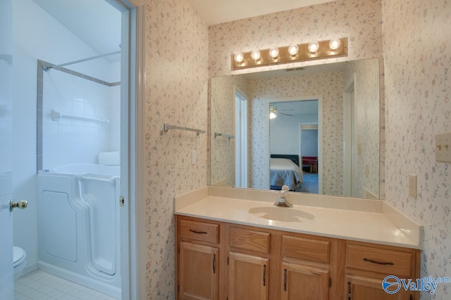 bathroom with toilet, vanity, ensuite bathroom, and wallpapered walls