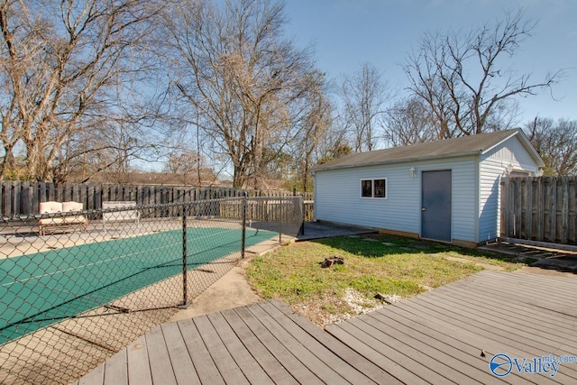 wooden deck with a fenced in pool, an outbuilding, a patio area, and a fenced backyard