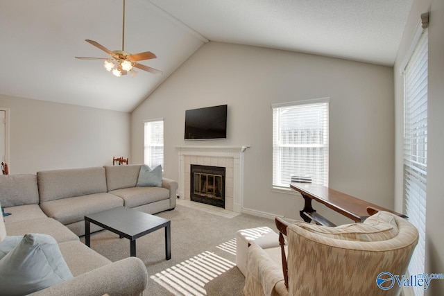 living area featuring a fireplace, a ceiling fan, light carpet, high vaulted ceiling, and baseboards