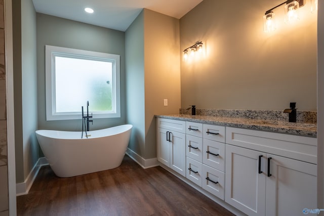 55 Edgewood St, Rainsville, AL 35986 - bathroom with baseboards, wood finished floors, a freestanding bath, double vanity, and recessed lighting