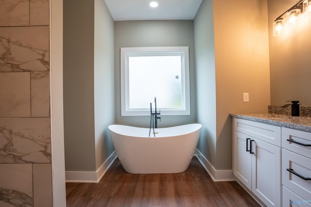 55 Edgewood St, Rainsville, AL 35986 - bathroom with wood finished floors, a freestanding bath, baseboards, and vanity