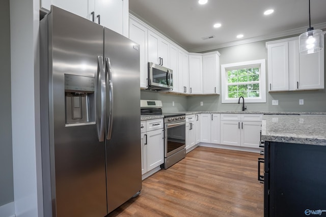 55 Edgewood St, Rainsville, AL 35986 - kitchen with stainless steel appliances, crown molding, light wood-style floors, light stone counters, and white cabinetry