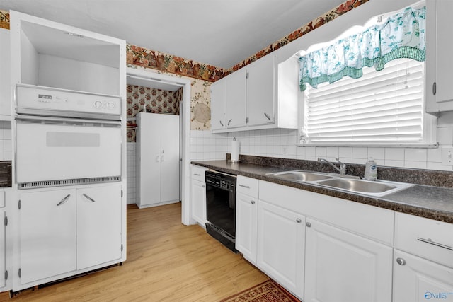 kitchen with dark countertops, white oven, a sink, and dishwasher