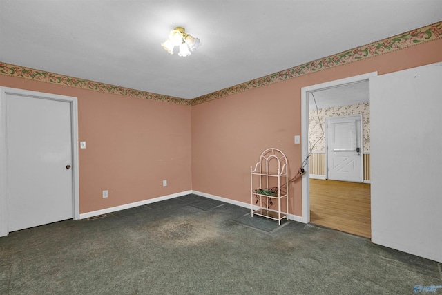 empty room with baseboards and carpet