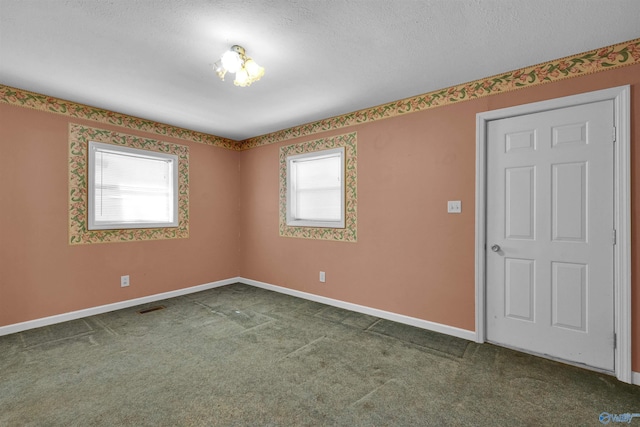 carpeted empty room with baseboards and a textured ceiling