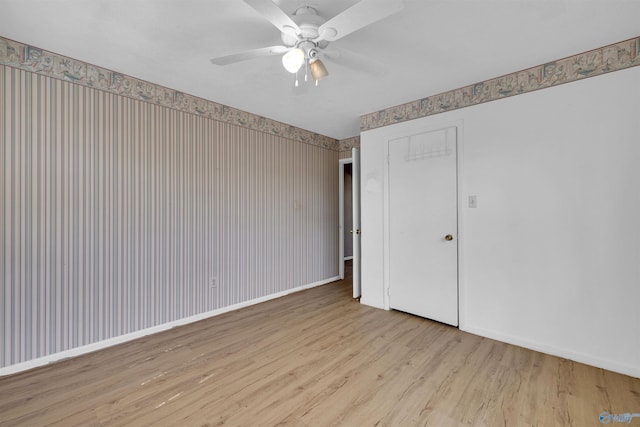unfurnished bedroom with wallpapered walls, wood finished floors, and baseboards