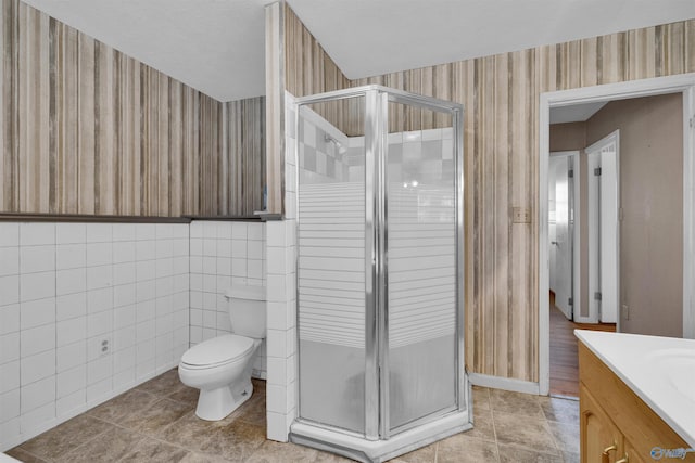 bathroom featuring tile patterned flooring, wallpapered walls, toilet, and a stall shower
