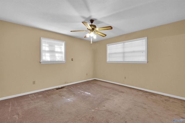 unfurnished room with visible vents, baseboards, carpet flooring, and ceiling fan