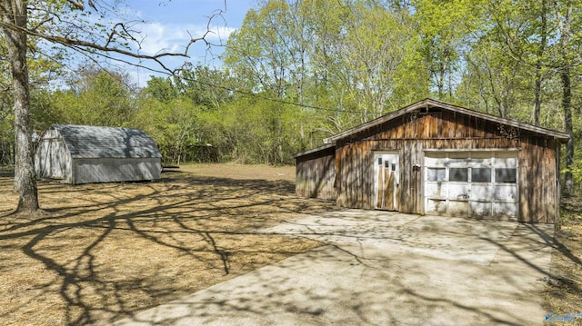 view of outbuilding with driveway and an outbuilding